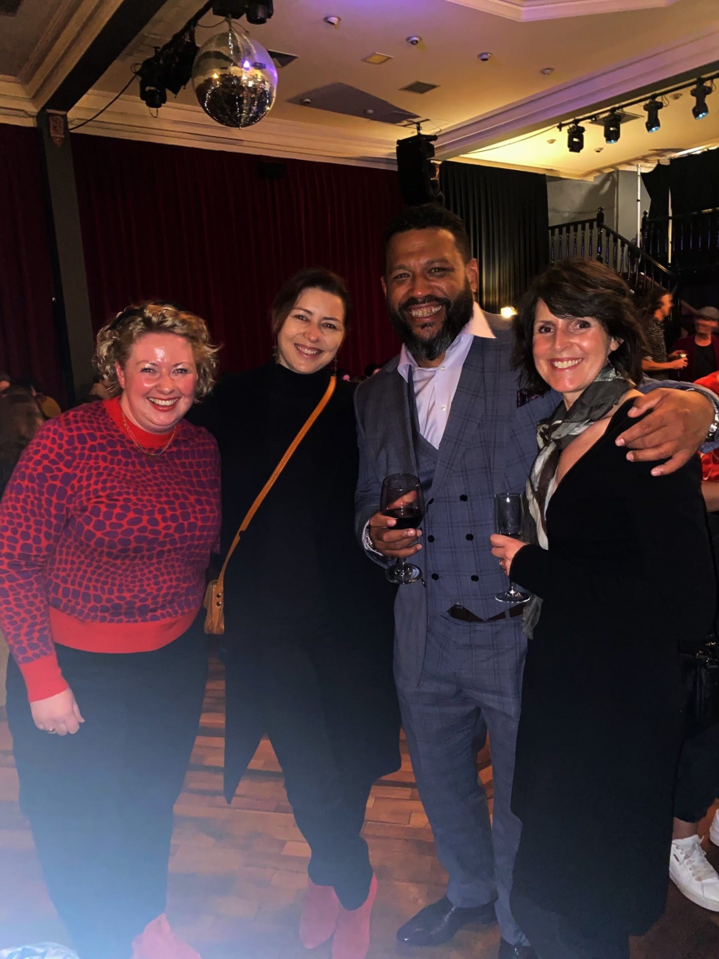 Photo of four people smiling at the camera. 
