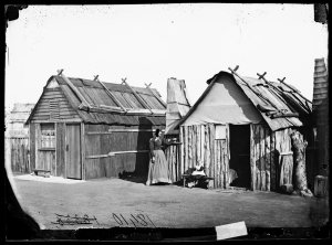 Photo taken 1870s. Louisa Lawson and her son Charles William in front of their bark hut, Gulgong area.