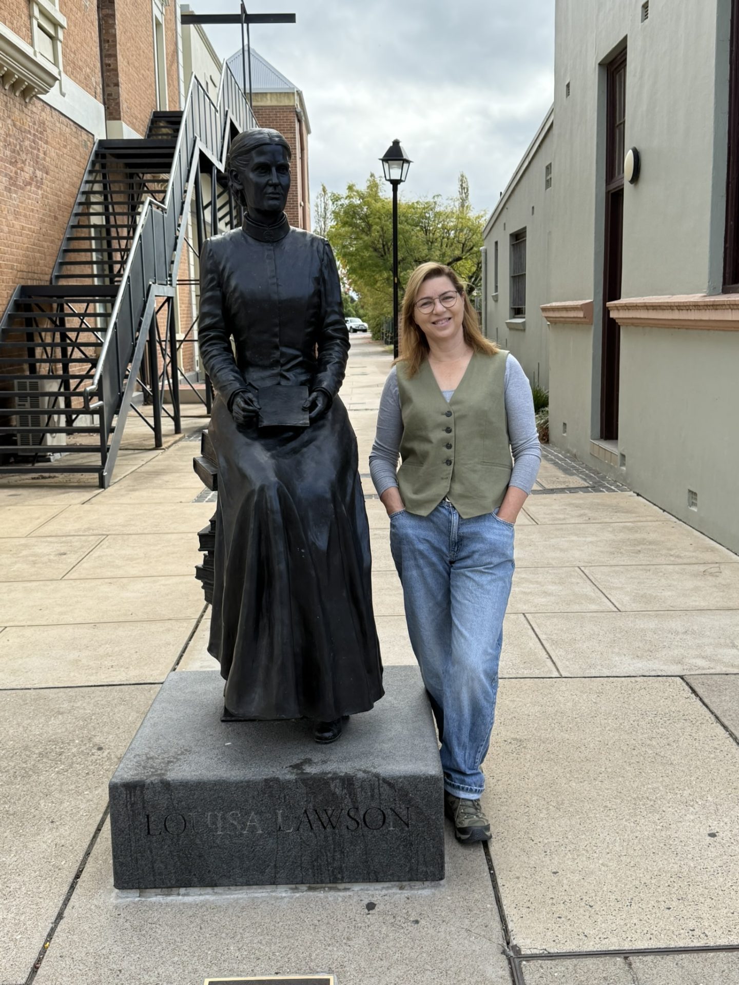 Biographer Michelle Scott Tucker stands next to Louisa Lawson's statue
